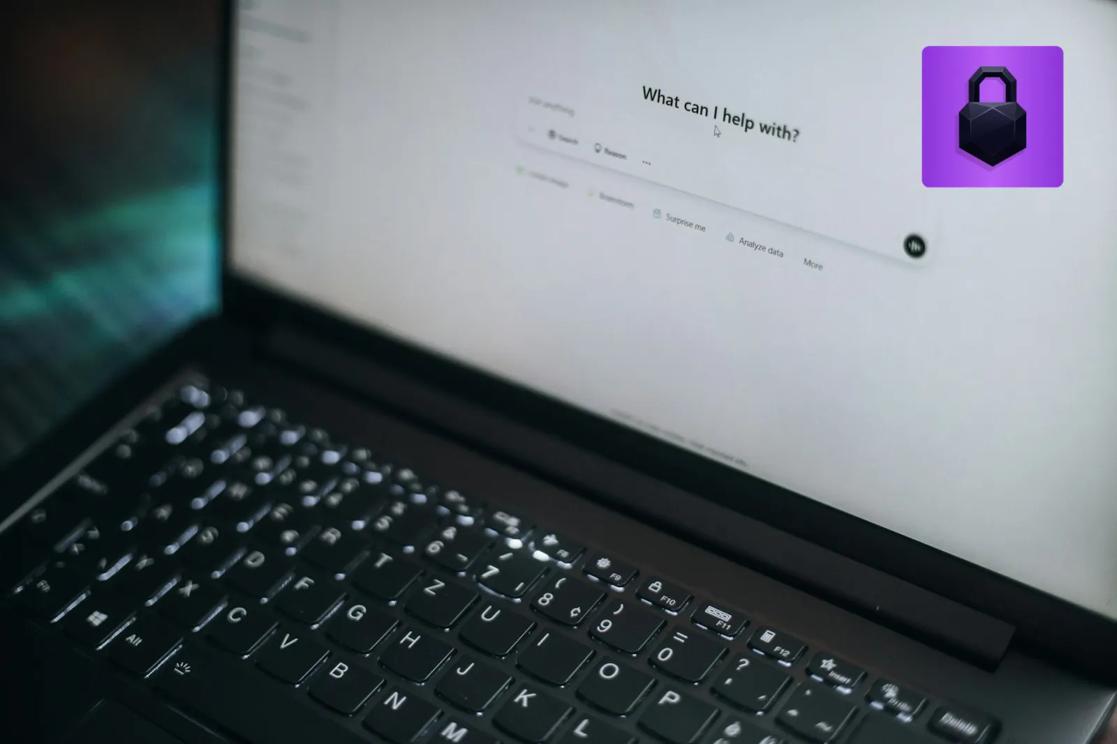 A laptop screen showing an AI chatbot prompt that reads "What can I help with?"