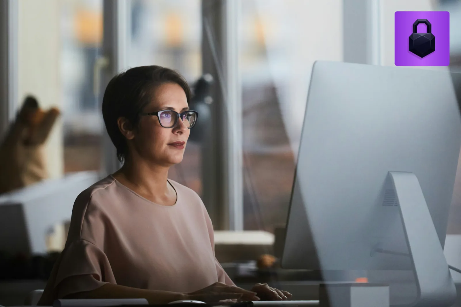 A lawyer working at a computer in a modern office, with a lock icon marking secure documents